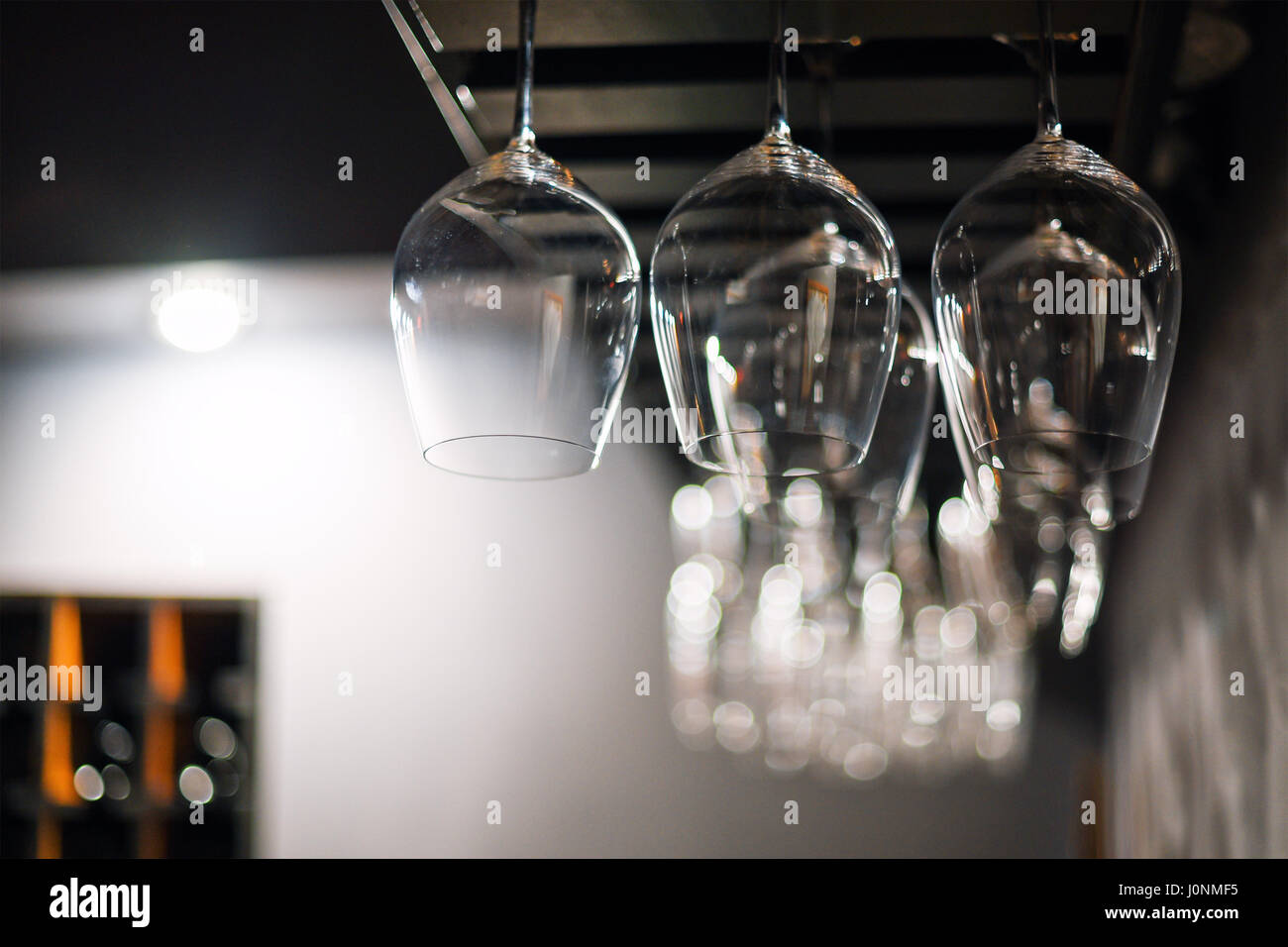 Empty glasses hanging over a bar rack in restaurant Stock Photo