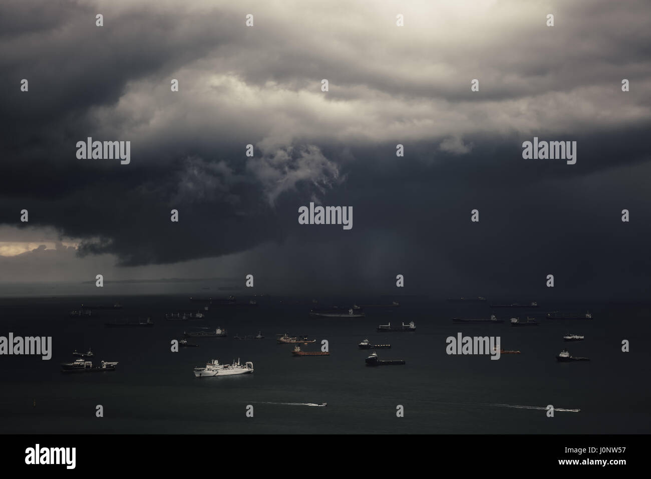 Cloudy sky above the Singapore Strait with variety of traid and fishing vessels whichi are occuping the whole territory of water area. The Singapore S Stock Photo