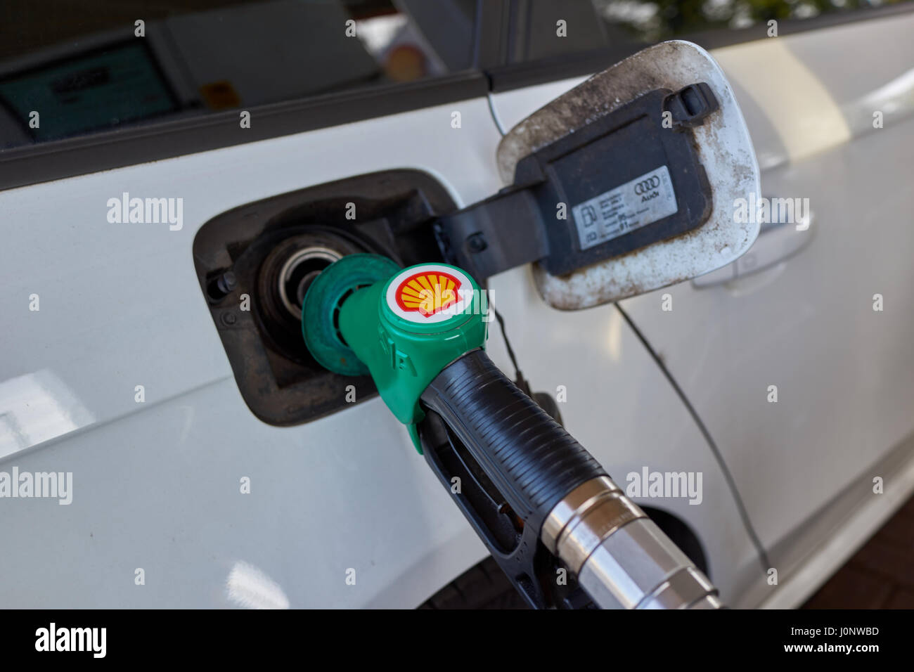 Filling up car with unleaded petrol at shell service station. Stock Photo