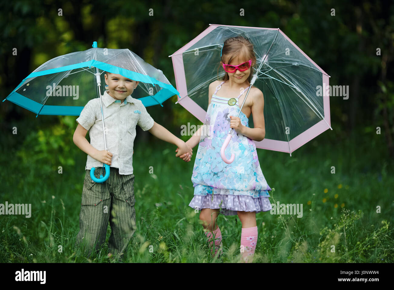 Kids playing in rain umbrella hi-res stock photography and images - Alamy