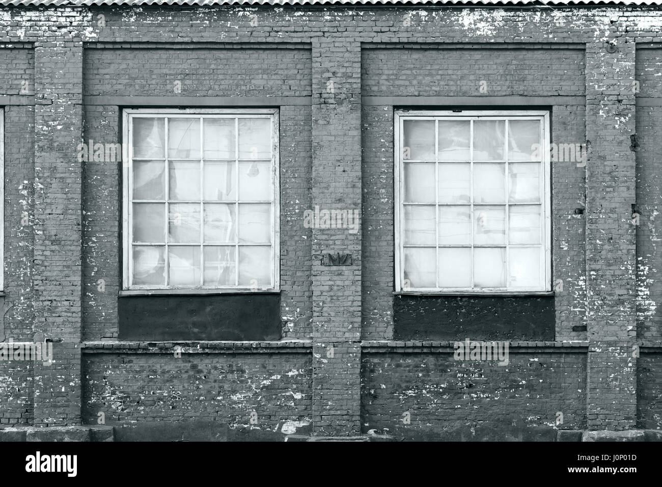 brick wall of an old factory building facade with windows Stock Photo
