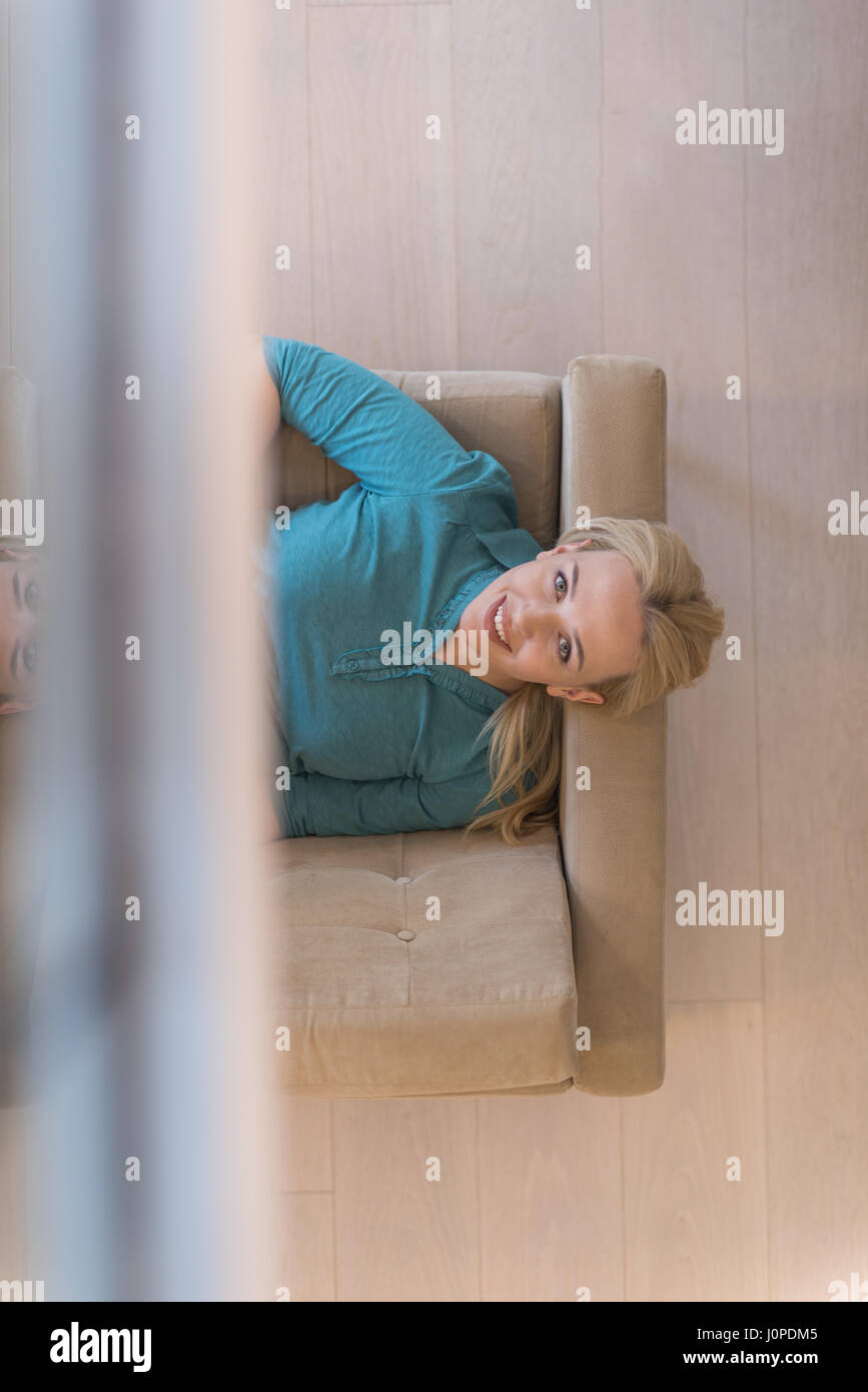 young happy woman on sofa using tablet computer at luxury home Stock ...