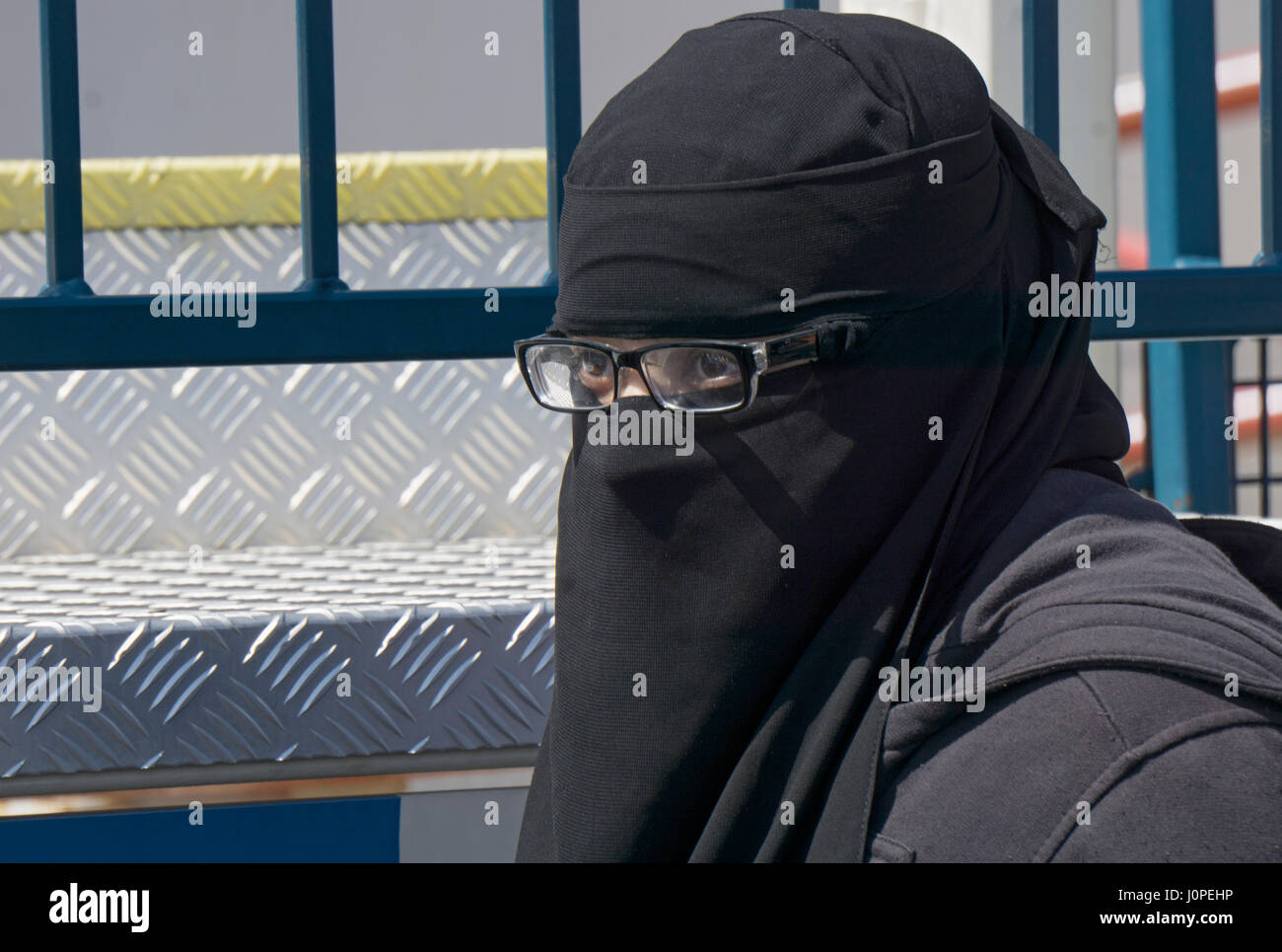 An Islamic woman in a burka with only her eyes and glasses showing at Luna Park in Coney Island, Brooklyn, New York City. Stock Photo