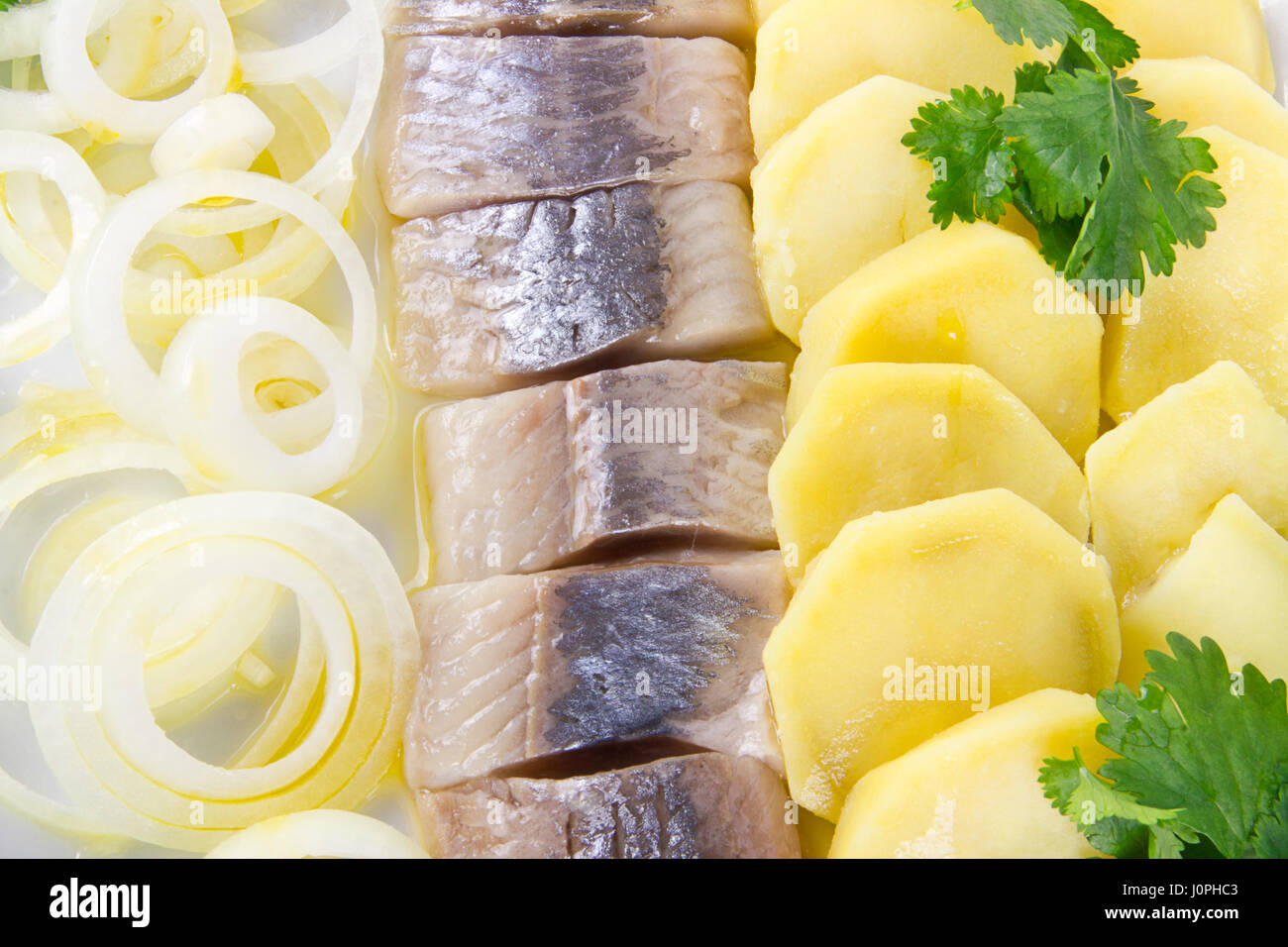 Portion of herring fish fillets with potato and onion Stock Photo Alamy