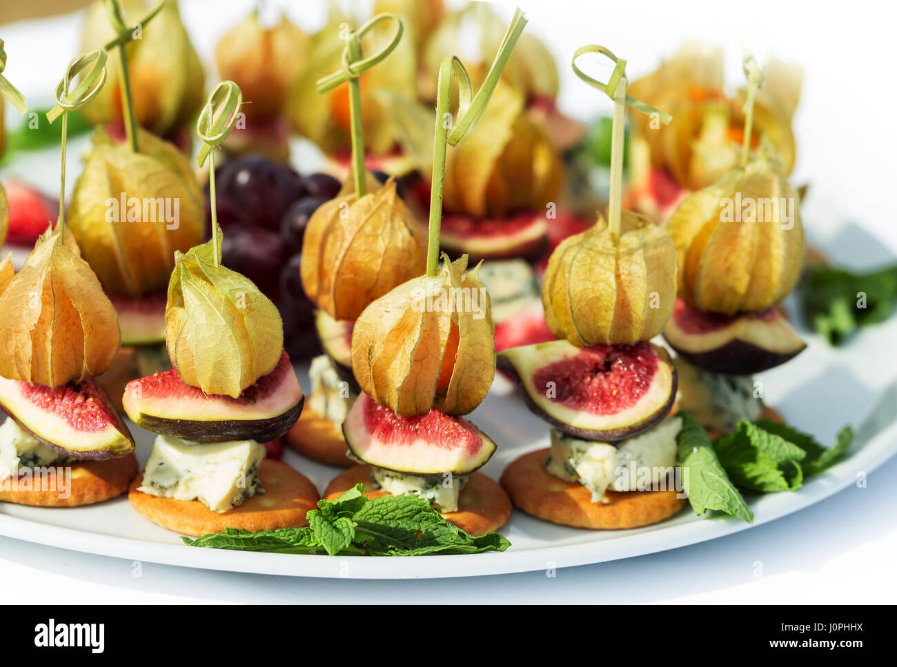 Canapes with physalis, fig, cheese and crackers Stock Photo