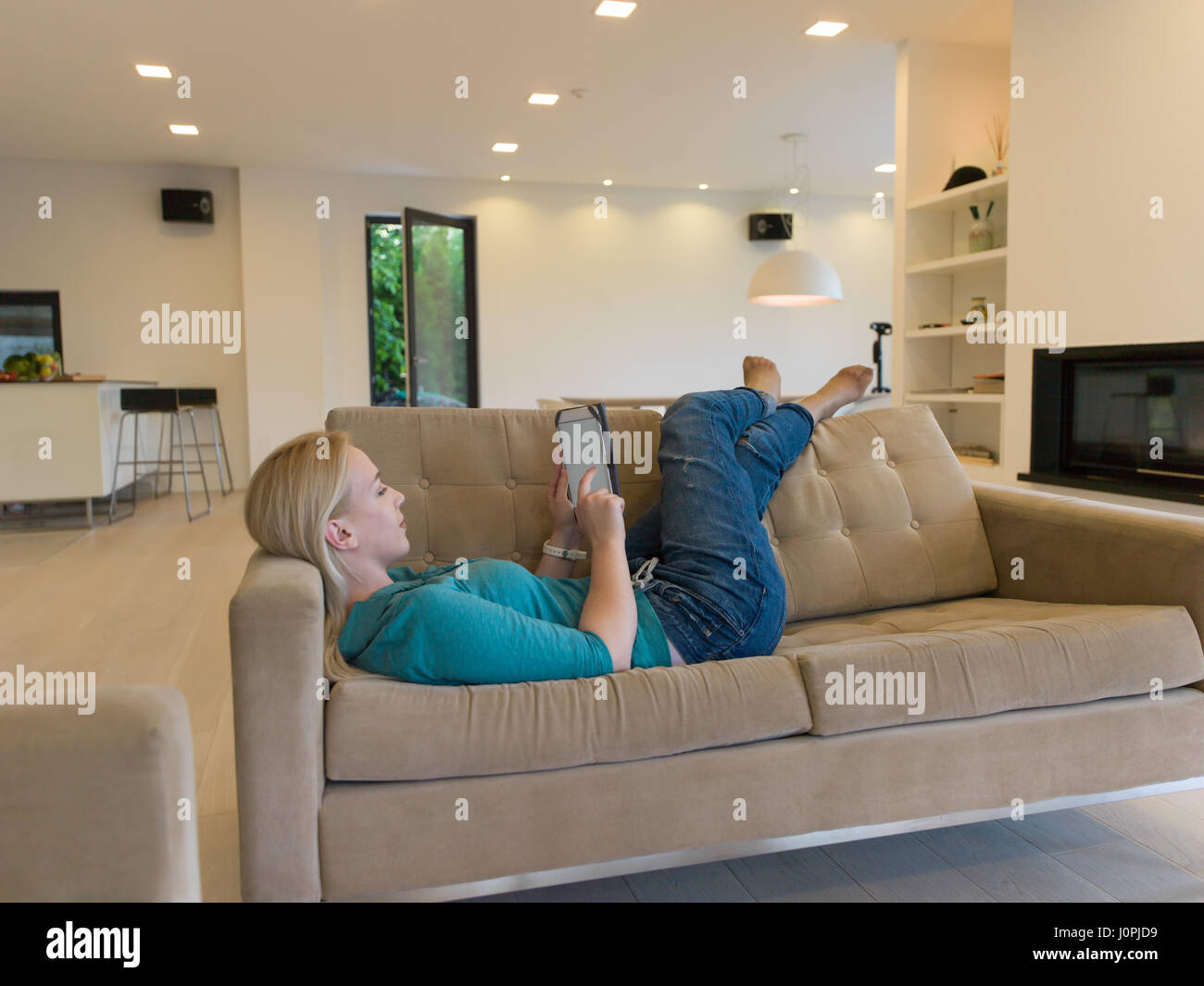 young happy woman on sofa using tablet computer at luxury home Stock ...