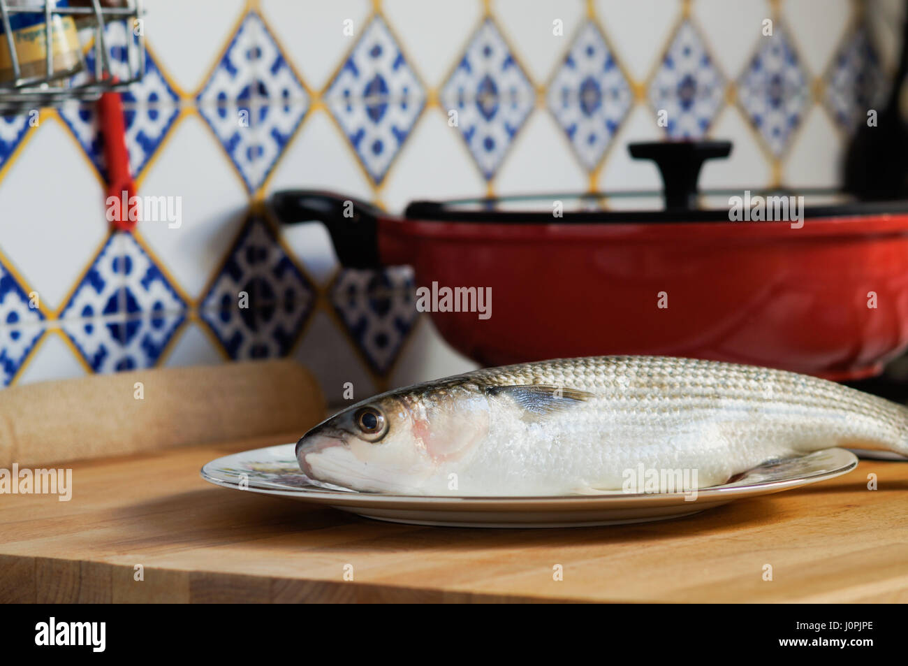 Mullet striped mullet contains omega-3 acids, vitamins and minerals. Mullet lying on plate ready for cooking. Stock Photo
