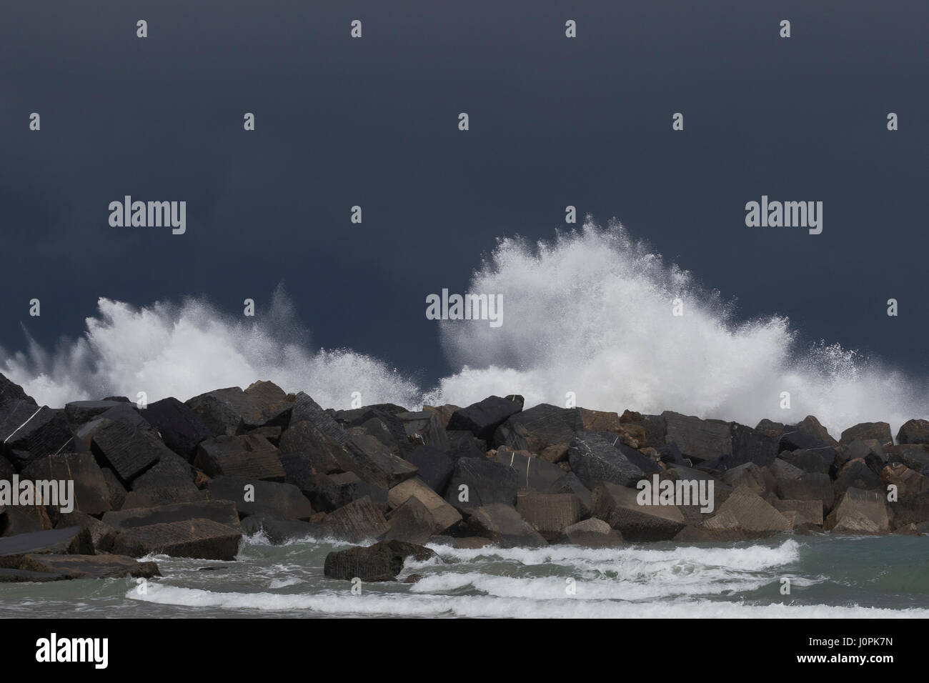 Big waves splashing in breakwater blocks in a storm day in La Zurriola beach (San Sebastian, Spain) 2017. Stock Photo