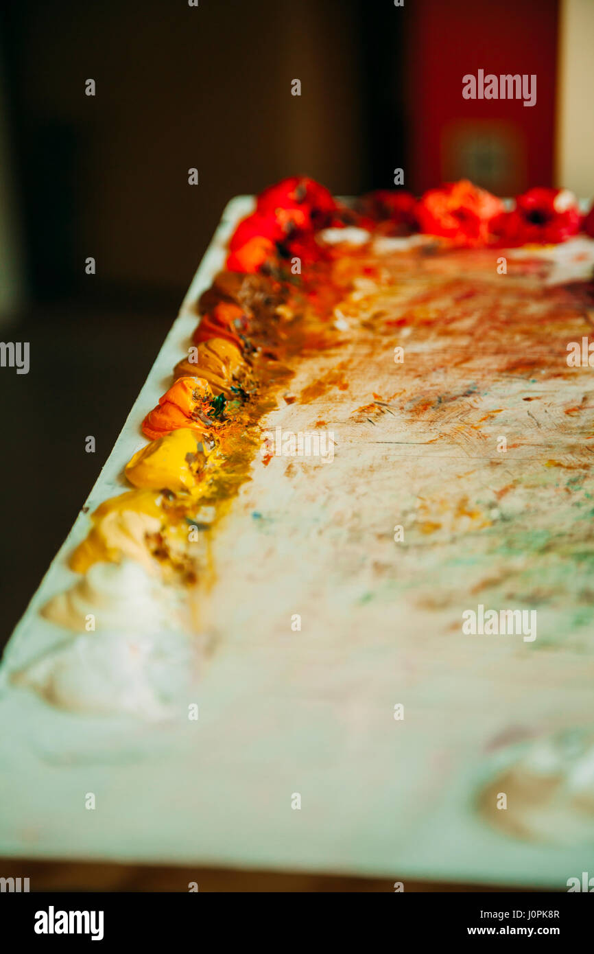 Colorful mixture of oil paints on an palette with a blur background Stock Photo