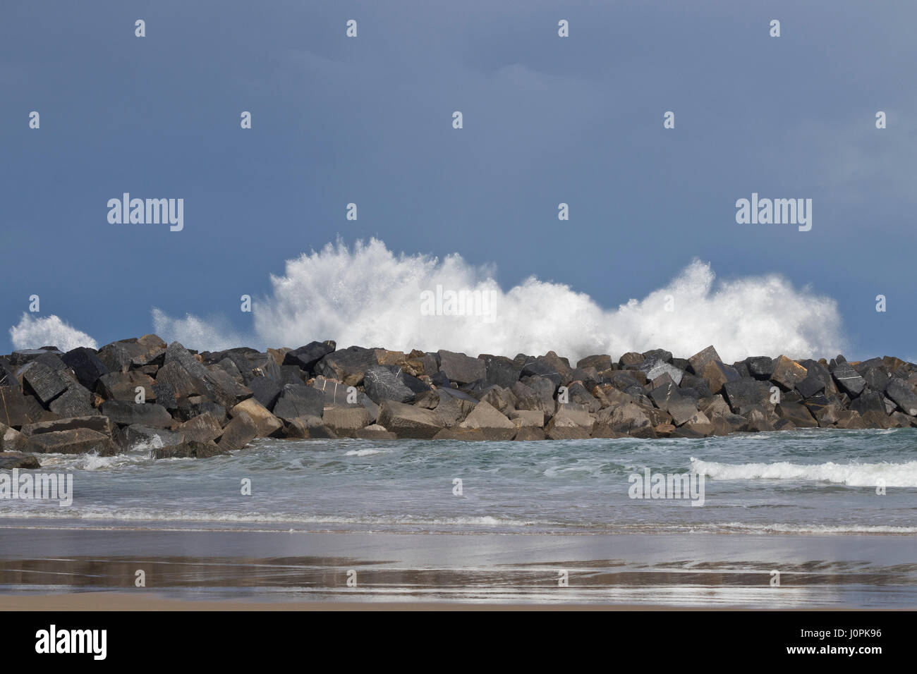 Beach protected from big waves by breakwater blocks in La Zurriola beach (San Sebastian, Spain) 2017. Stock Photo