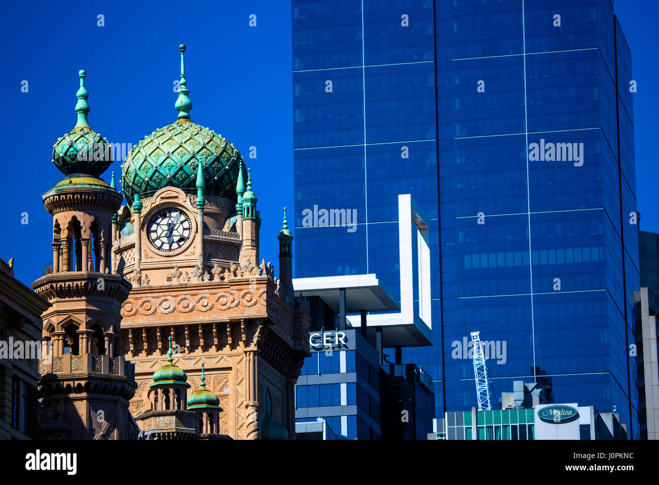 The clock tower of the Forum Theatre set against an office tower block in central Melbourne, Australia Stock Photo
