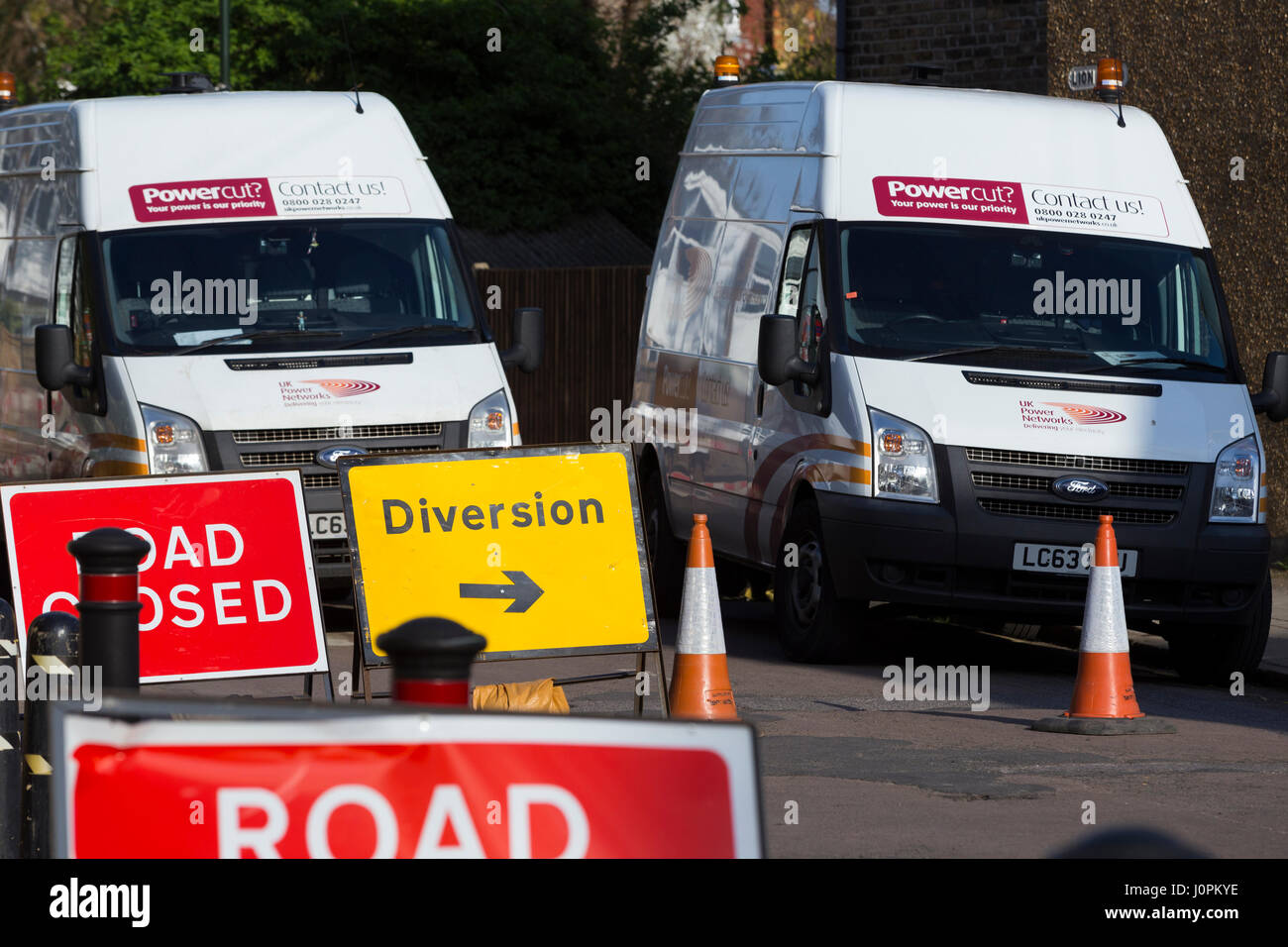 Sign / signs for road closed / roads closure  caused by emergency electricity / electrical road works / roadwork / roadworks / utility company. Stock Photo