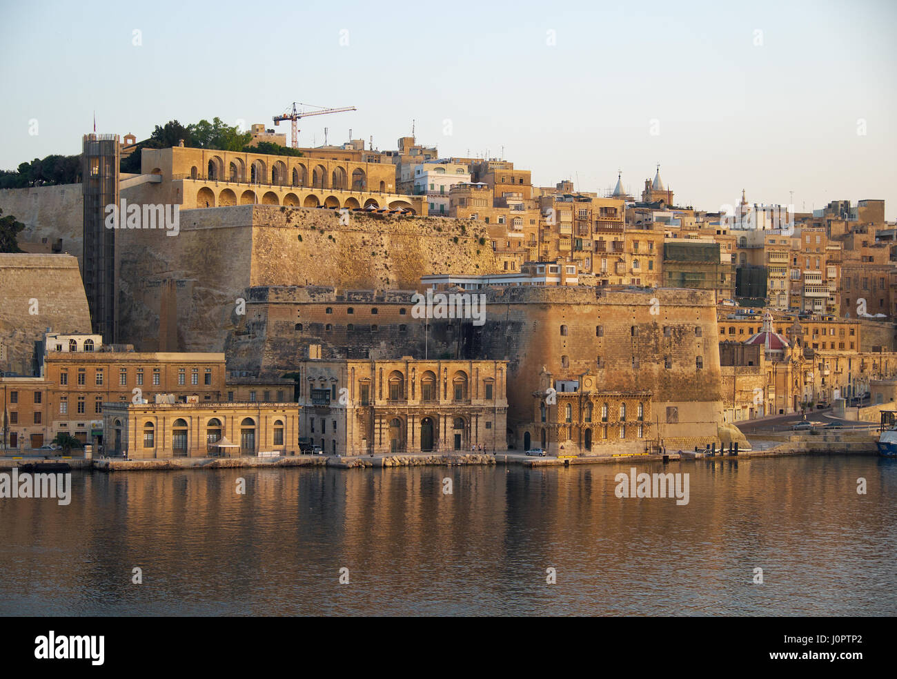 The view of Valletta fortifications with Fort Lascaris and Upper and Lower Barrakka Gardens  from the water of Grand Harbour. Malta Stock Photo