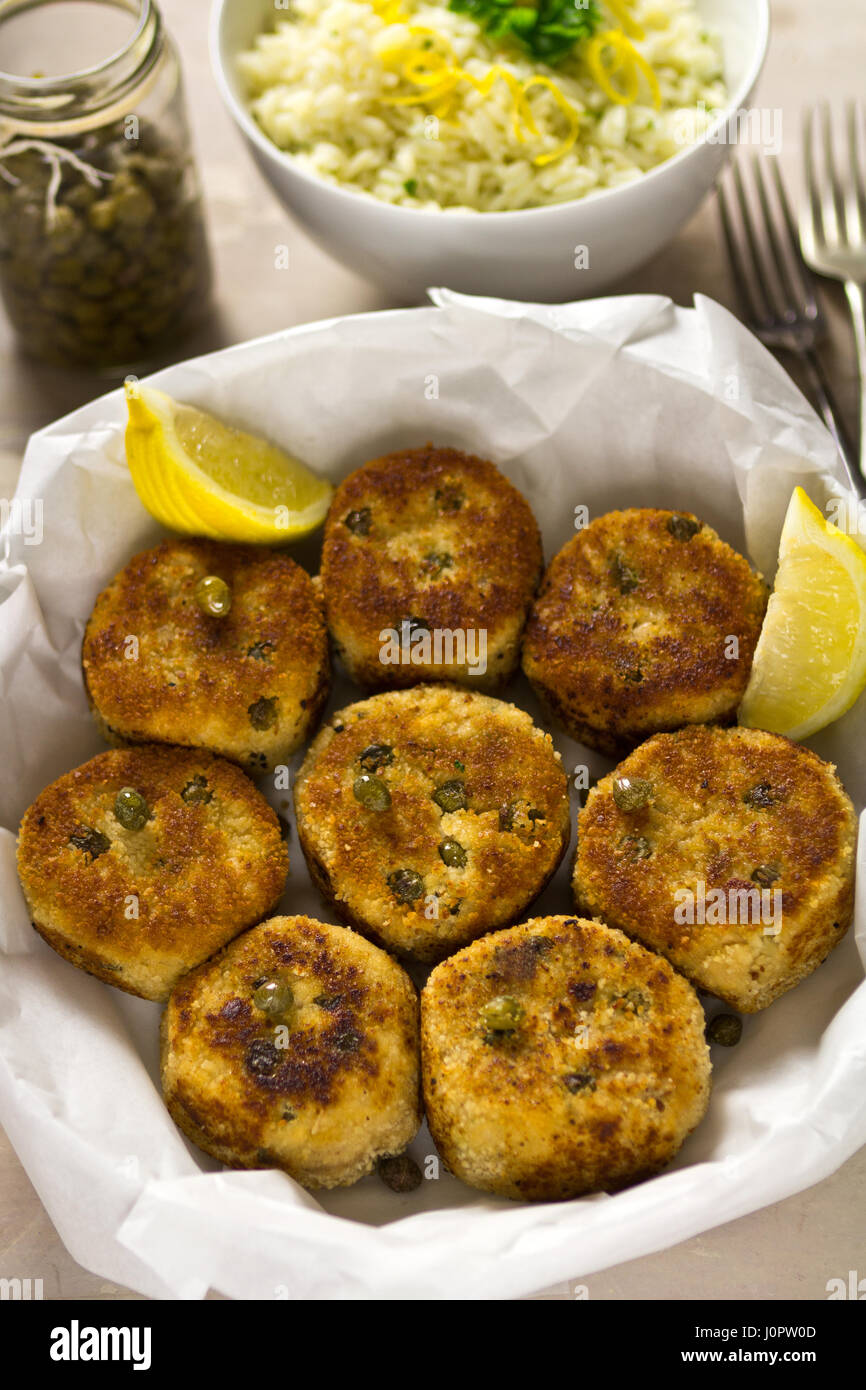 Fish cakes with capers and lemon wedges Stock Photo Alamy