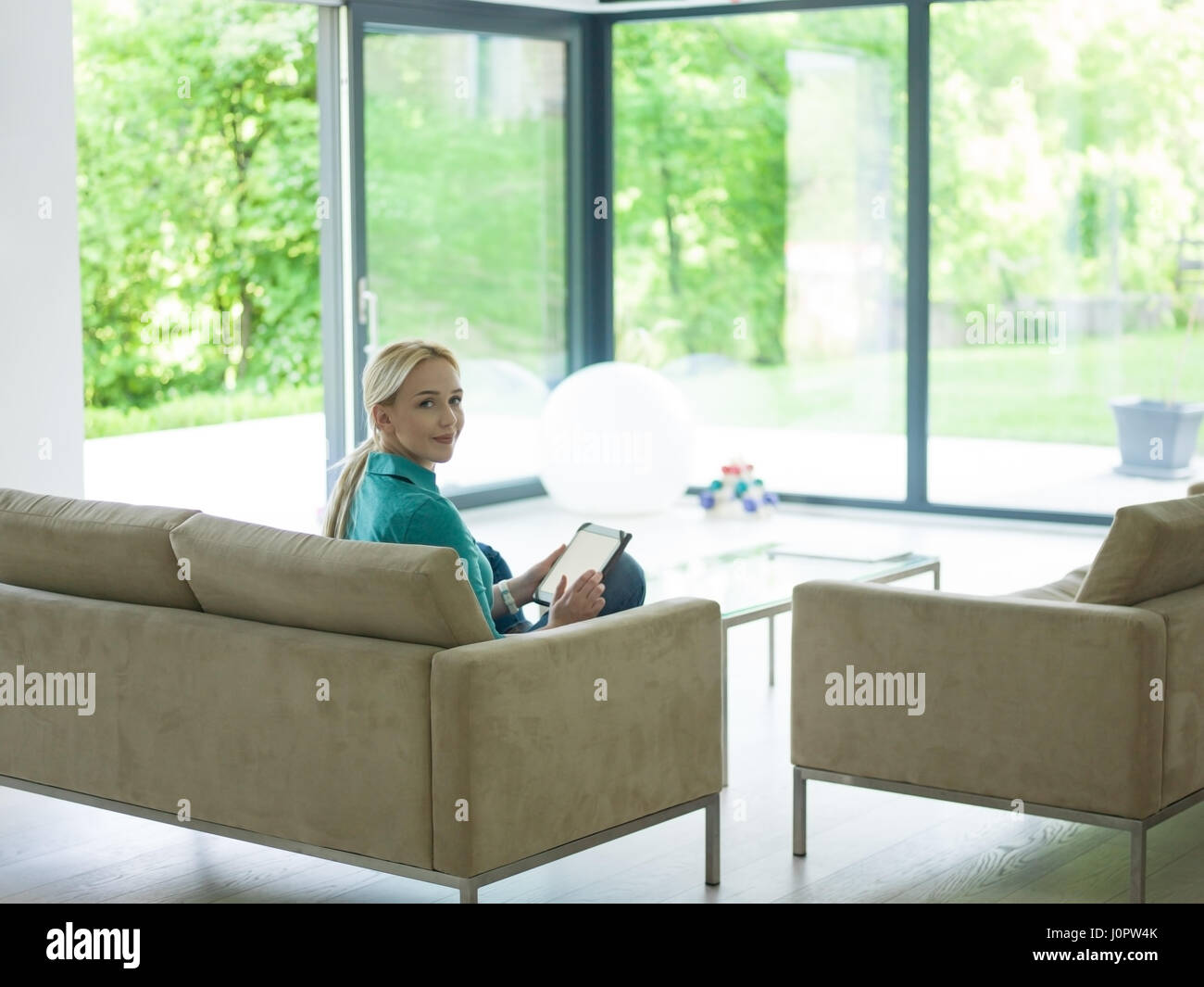 young happy woman on sofa using tablet computer at luxury home Stock ...