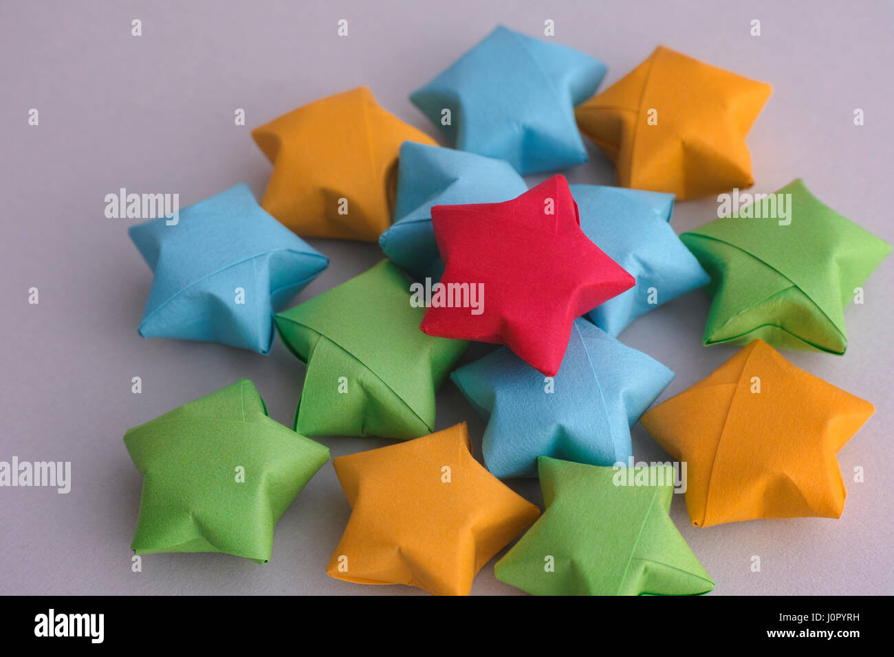 Colorful origami lucky stars on gray paper background. Stock Photo