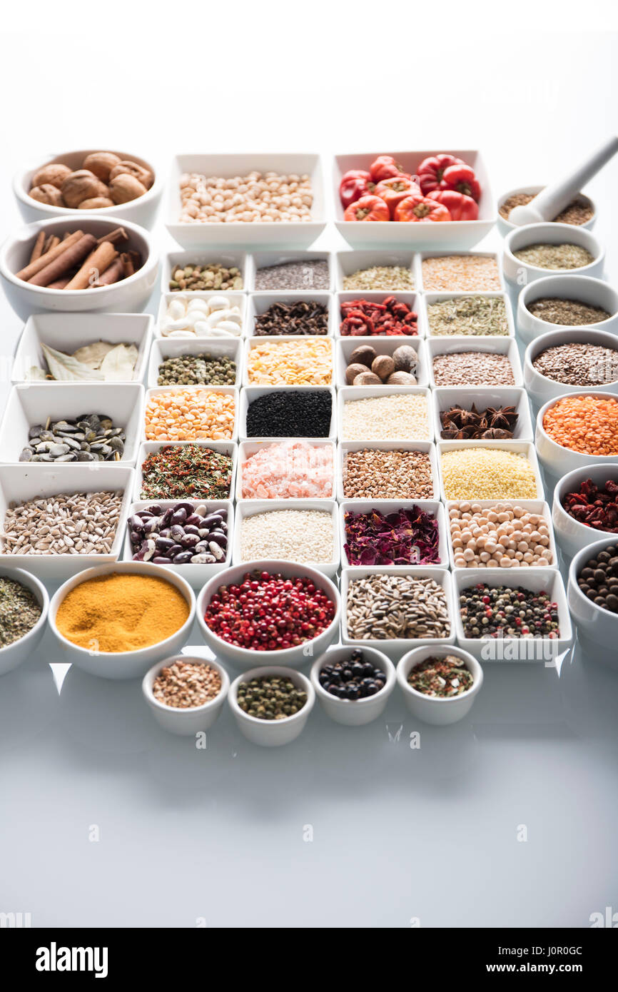 Spices and leguminous vegetables in bowls, isolated on white background