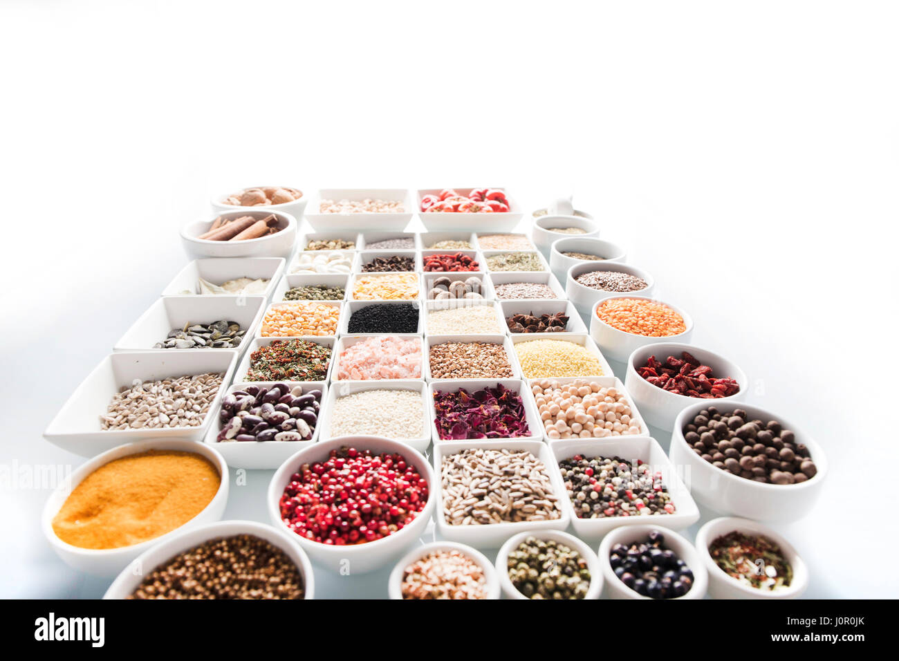 Spices and leguminous vegetables in bowls, isolated on white background