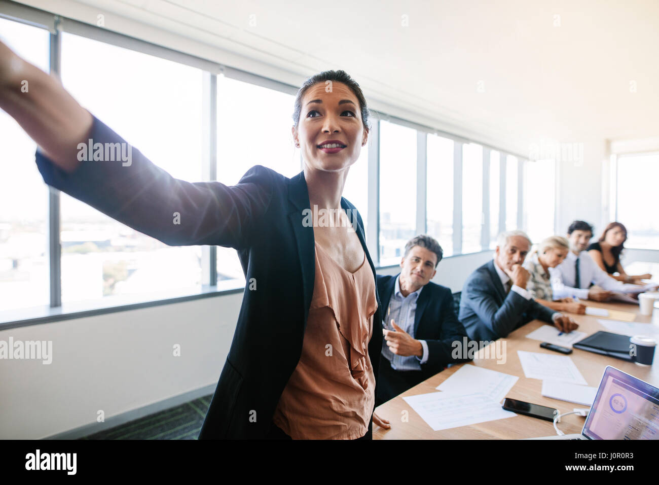 Presentation in modern conference room with asian businesswoman showing