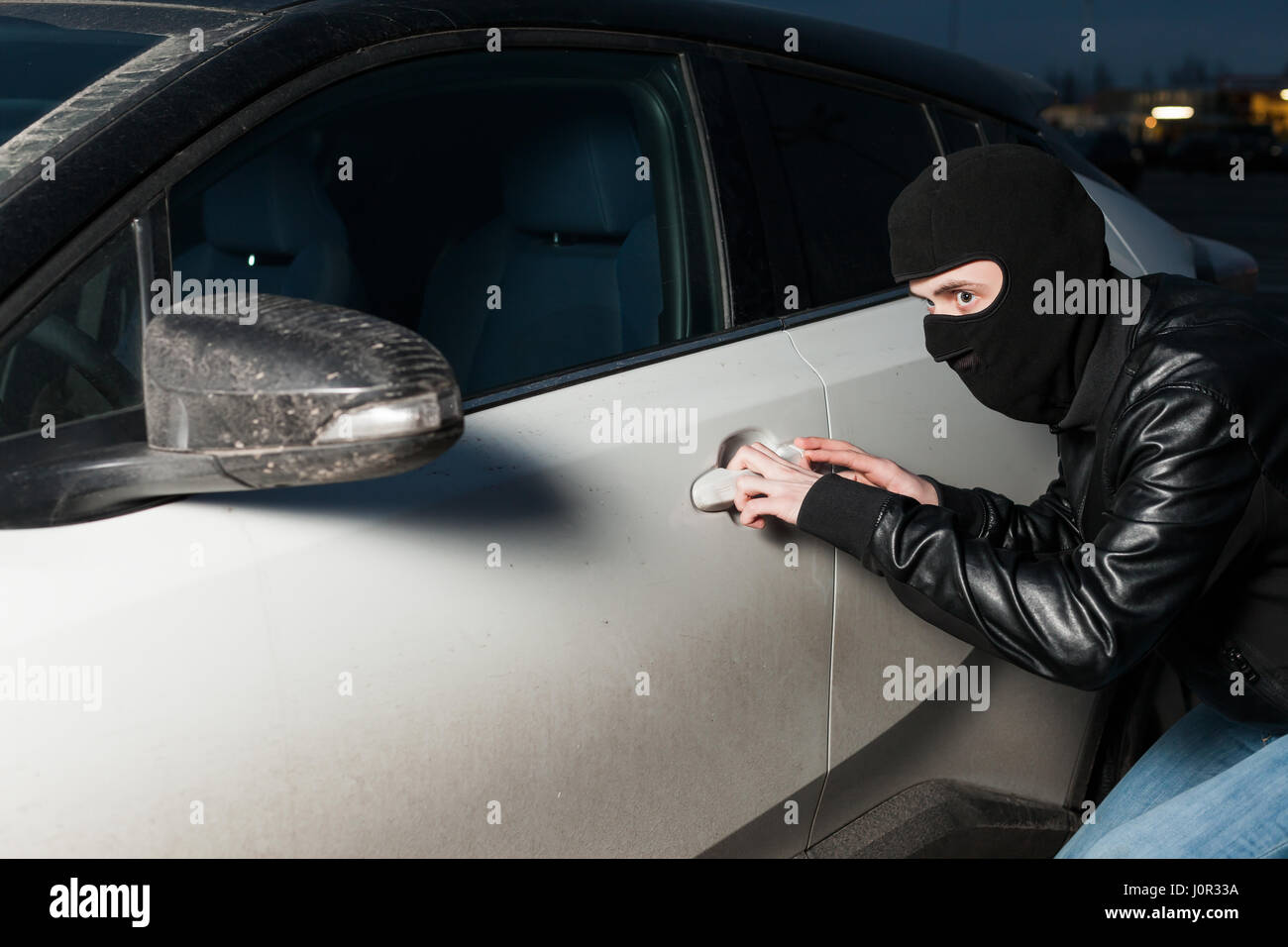 Carjacking danger, car insurance advertising concept. Male thief with