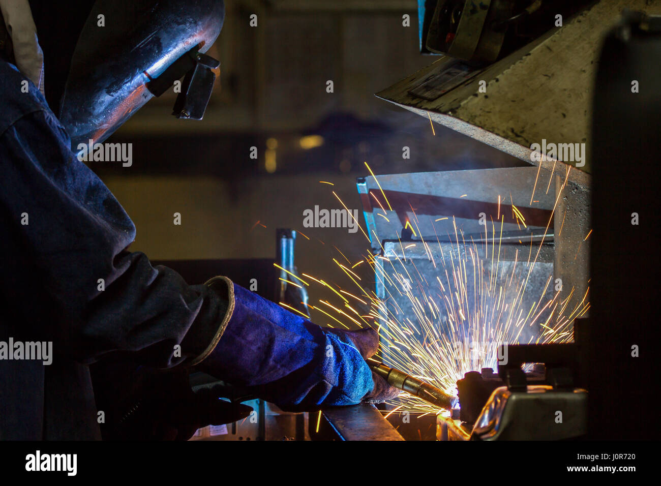 worker welding automotive part in car factory Stock Photo