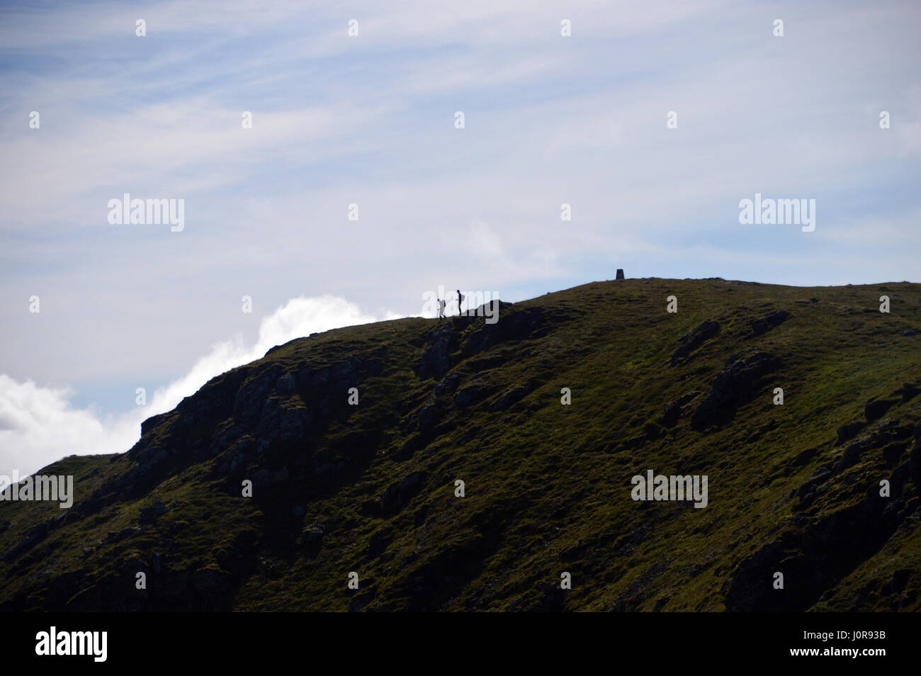 Silhouettes of a Pair of Walkers on the Summit of the Scottish Mountain Corbett Ben Ledi in the Trossachs National Park, Scottish Highlands. Stock Photo