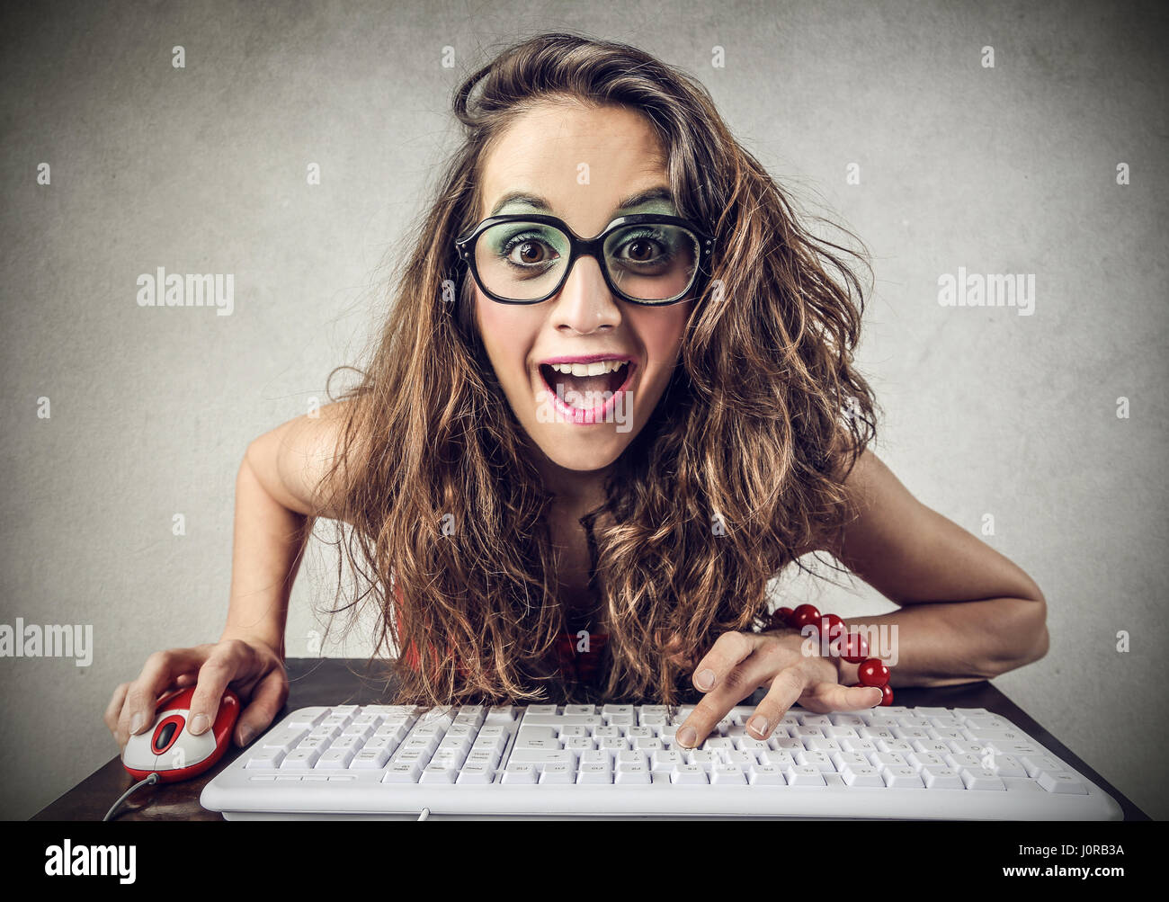 Brunette woman being excited in front of computer Stock Photo