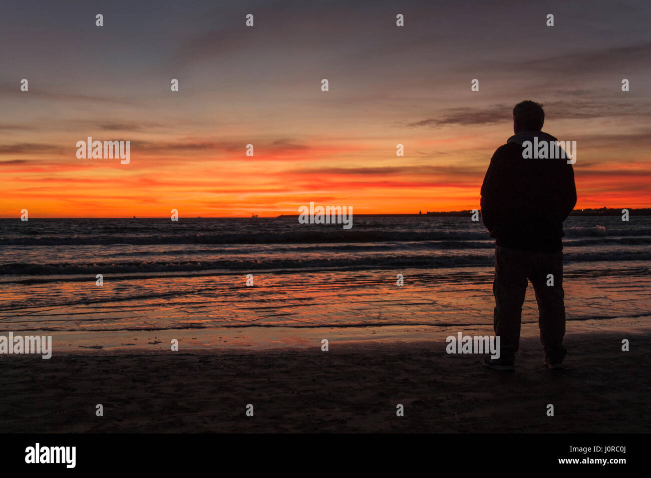 Silhouette of man on a beautiful sunset on the beach Stock Photo - Alamy