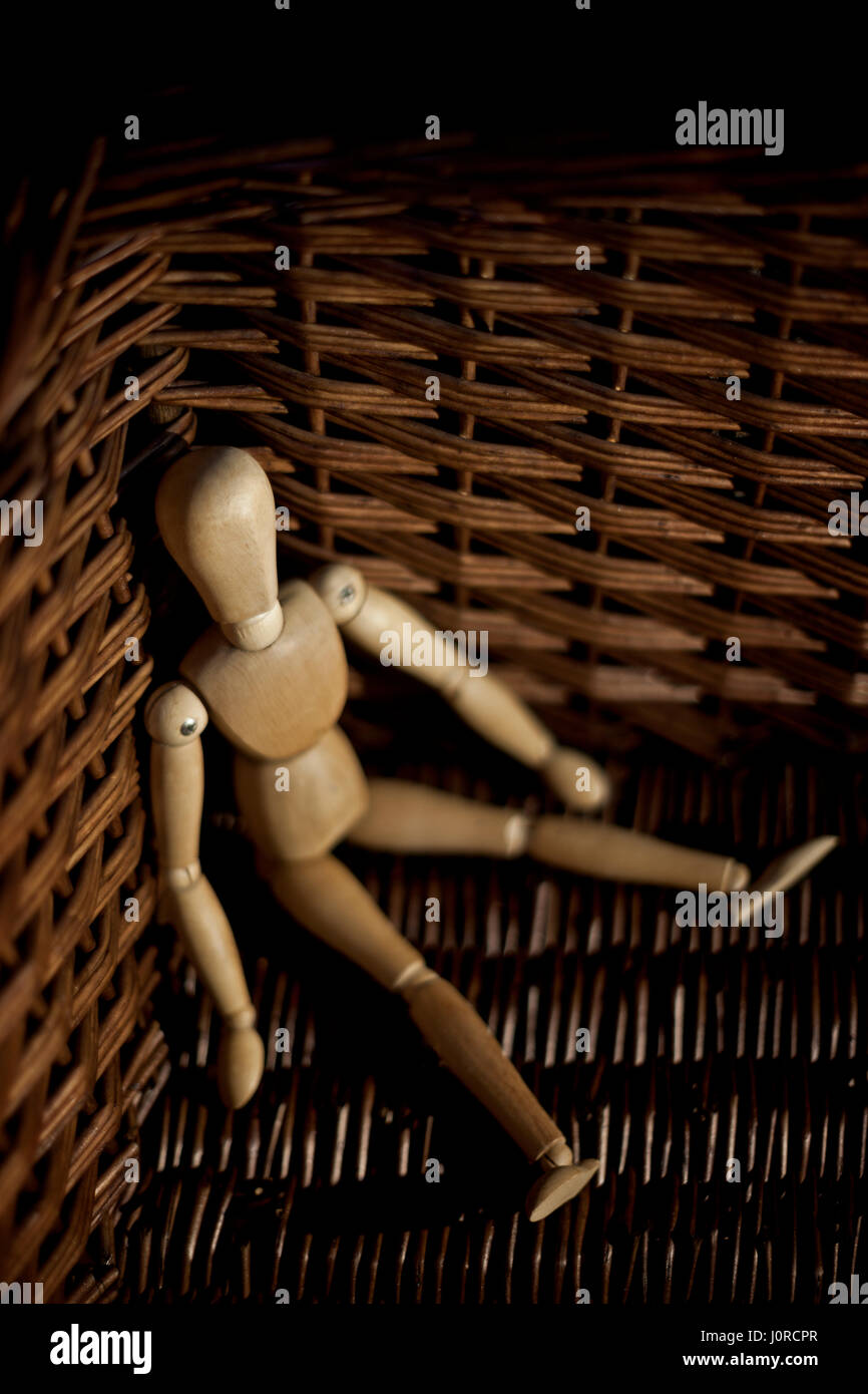 Wooden model mannequin in a wicker basket. Stock Photo