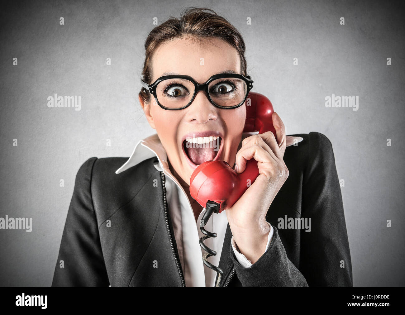 Excited businesswoman making a call with retro phone Stock Photo