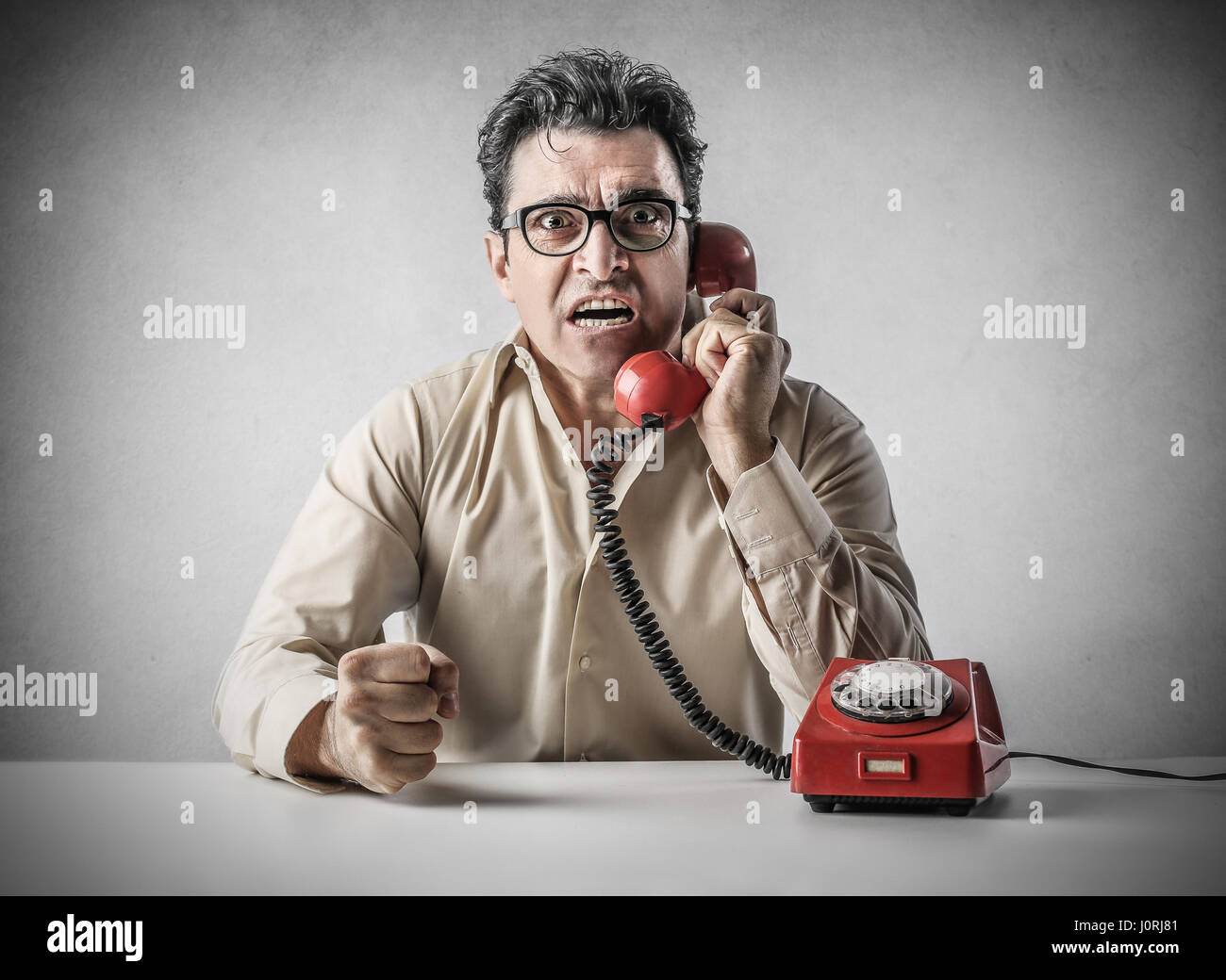 Mad man talking on retro phone Stock Photo