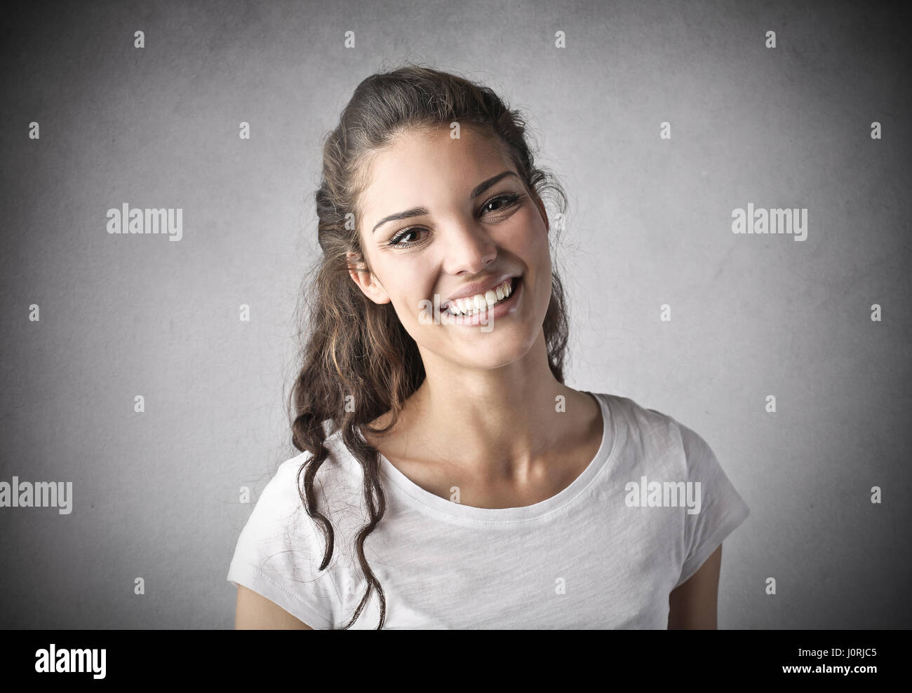 Brunette woman smiling inside Stock Photo