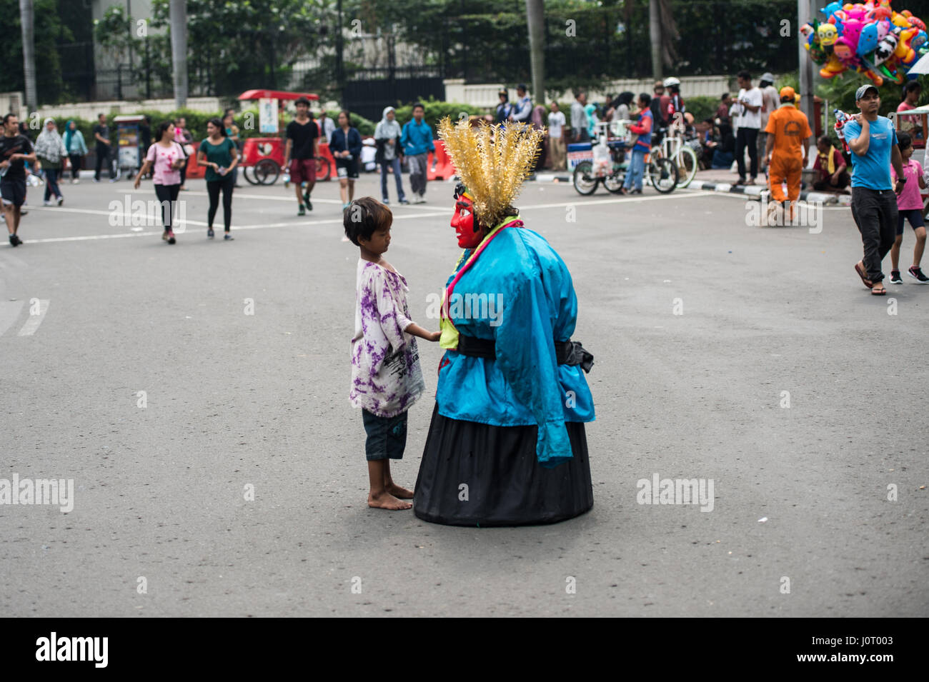 Jakarta. 16th Apr, 2017. A kid street performer with his Ondel-Ondel (Jakarta's native doll costume) stands on the street after performance during car free day in Jakarta, April 16, 2017. Credit: Veri Sanovri/Xinhua/Alamy Live News Stock Photo