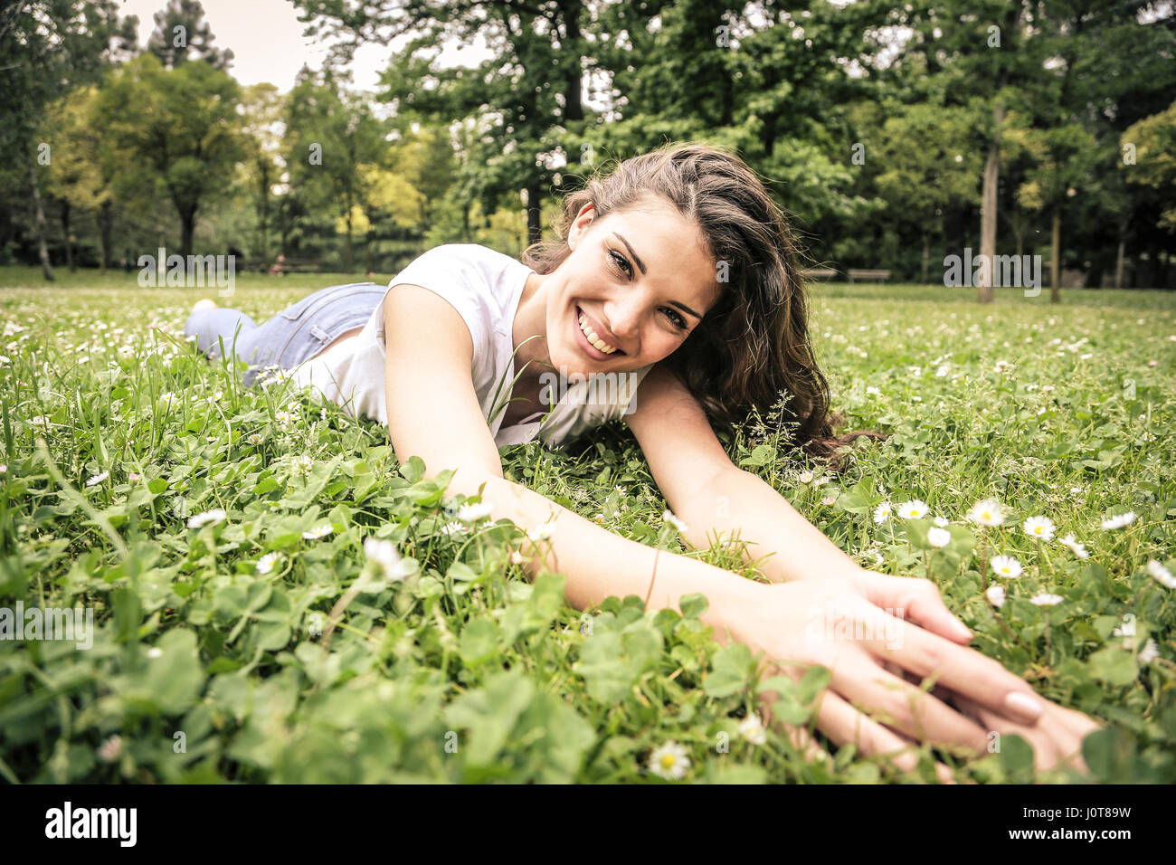 Pretty Lay Pretty brunette woman laying in the nature Stock Photo - Alamy