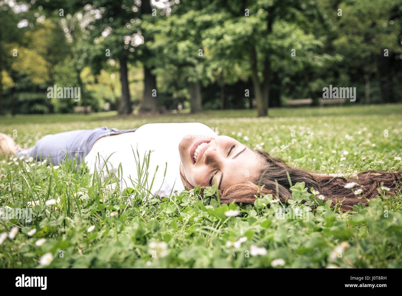 Brunette woman relaxing in the grass Stock Photo - Alamy