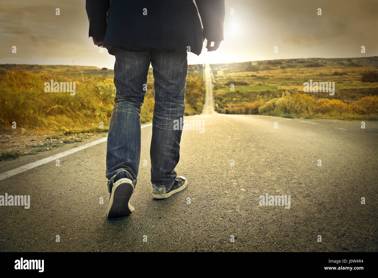 Lonely man walking on road Stock Photo