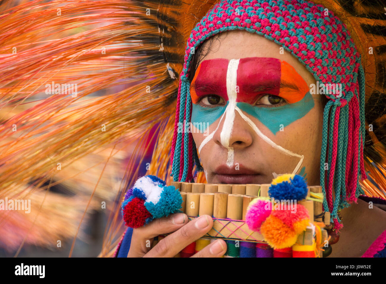 A young man in face paint playing a wind instrument at the Black and White Carnival in Pasto, Colombia. Stock Photo