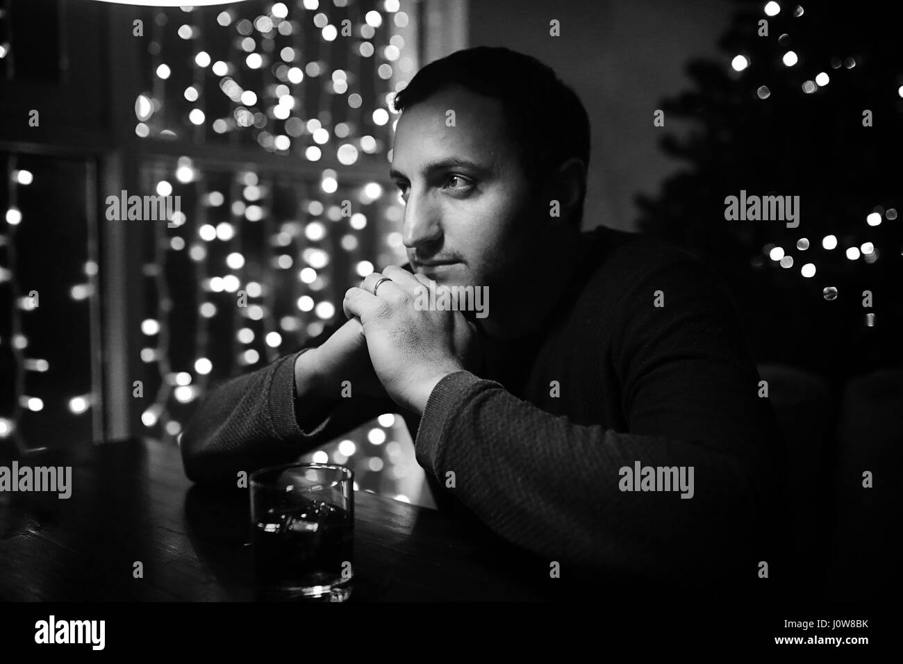 man holding glass of alcohol with ice in a night club  Stock Photo