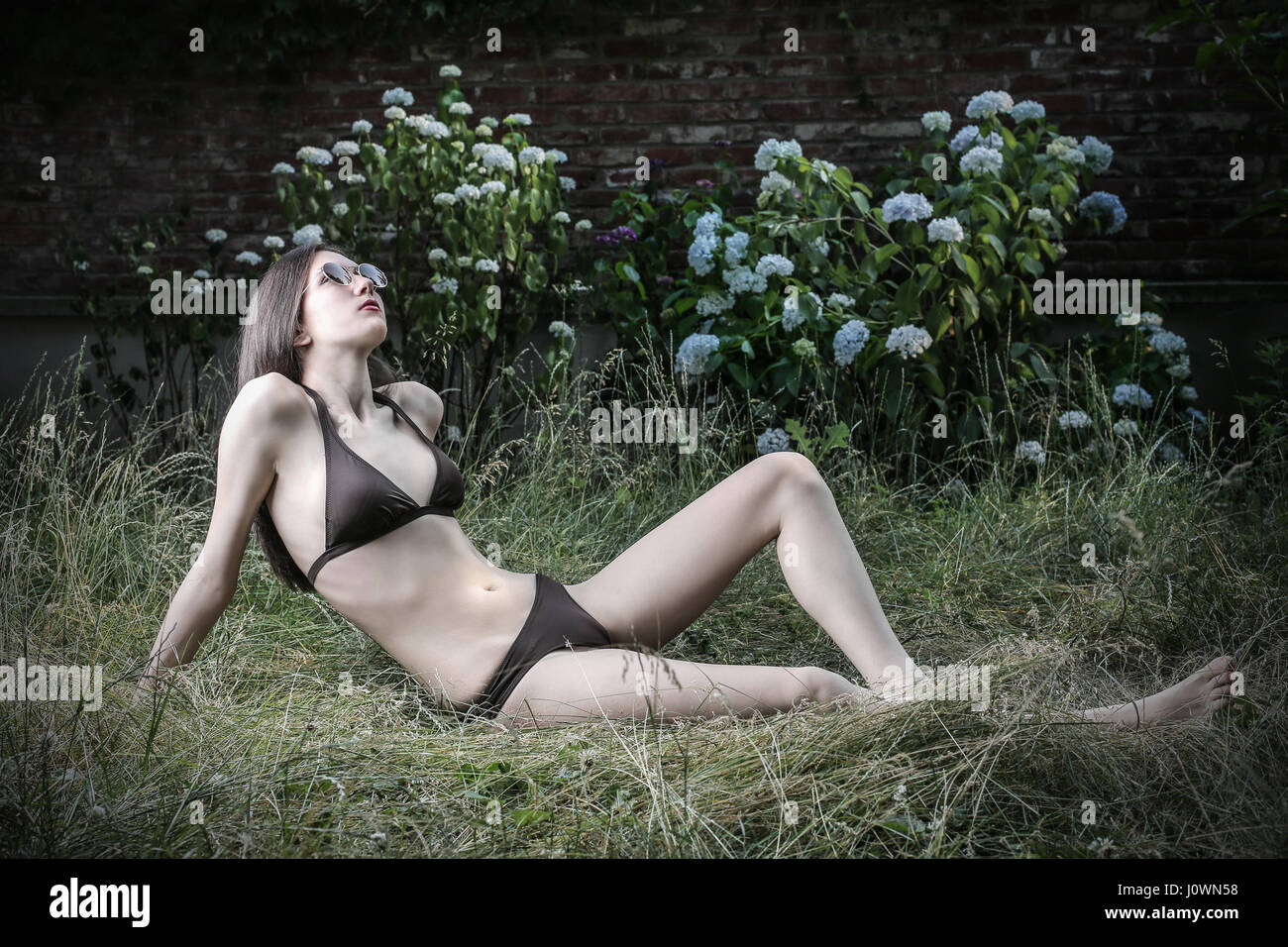 Young woman in bikini laying in garden Stock Photo