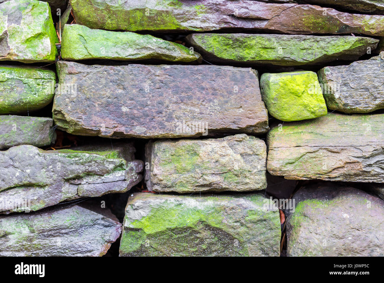a detail image of numerous weathered stones in a rock wall Stock Photo