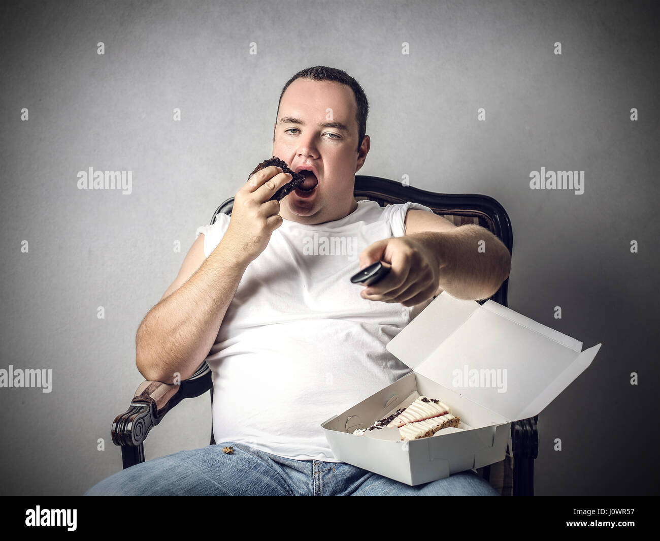 Fat man eating cookies inside Stock Photo