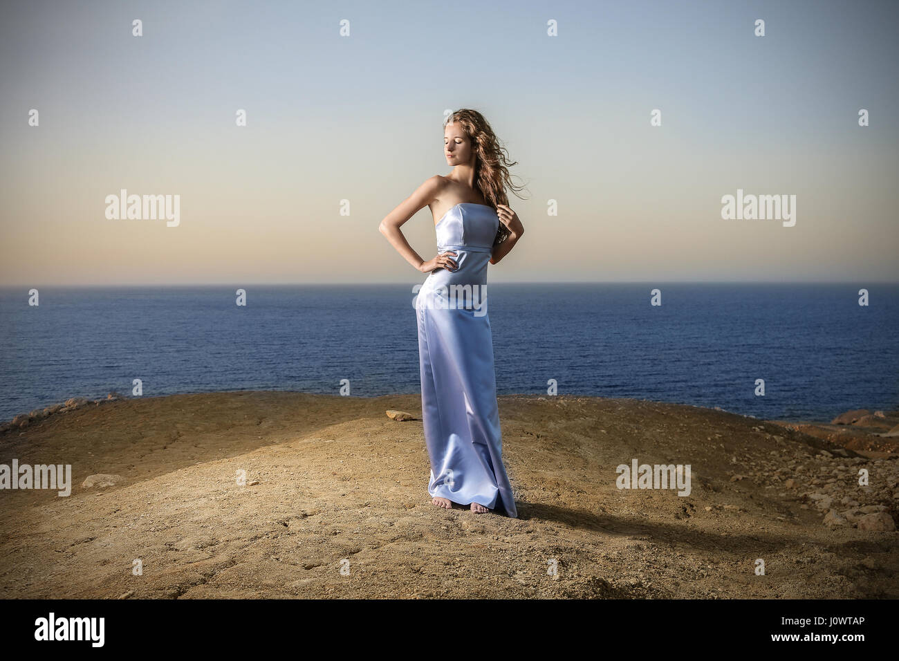 Woman in blue dress on the beach Stock Photo - Alamy