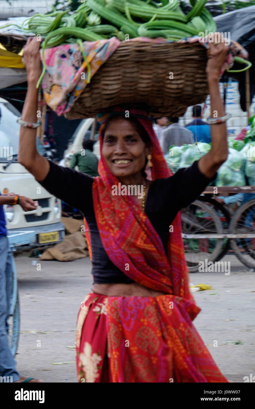 Lady in Asian market, India, with basket of goods on head Stock Photo