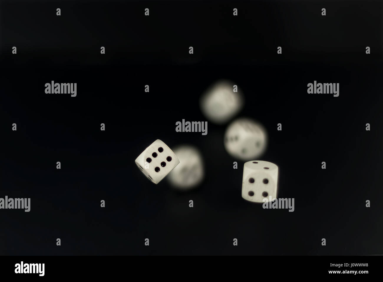 white dice roll in flight four and six in focus other motion blured Stock Photo