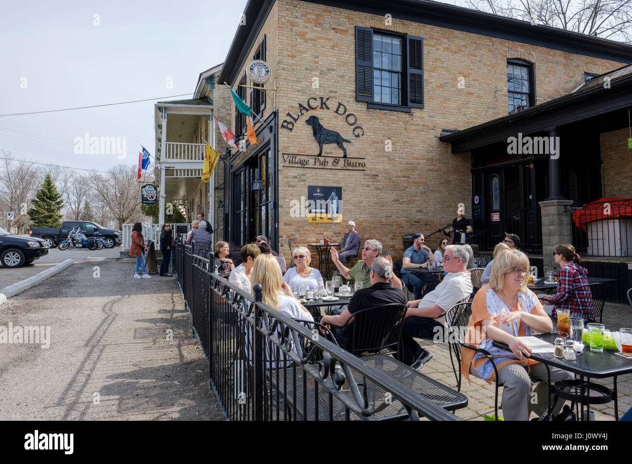 Customers sitting on tables on the outside patio at Black Dog Village Pub & Bistro, a bar, pub, restaurant in the Village of Bayfield, Ontario. Stock Photo