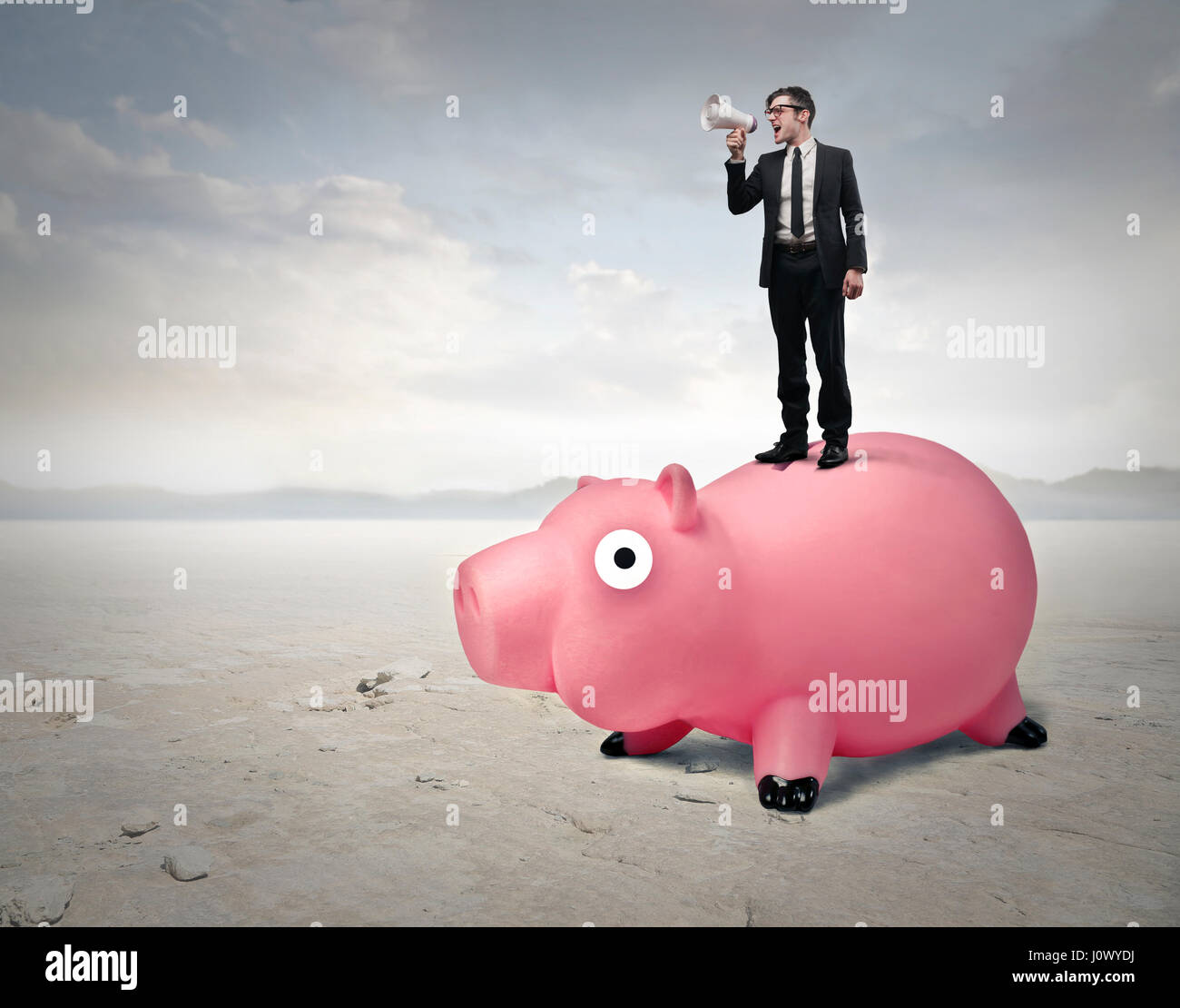 Businessman standing on piggy bank Stock Photo