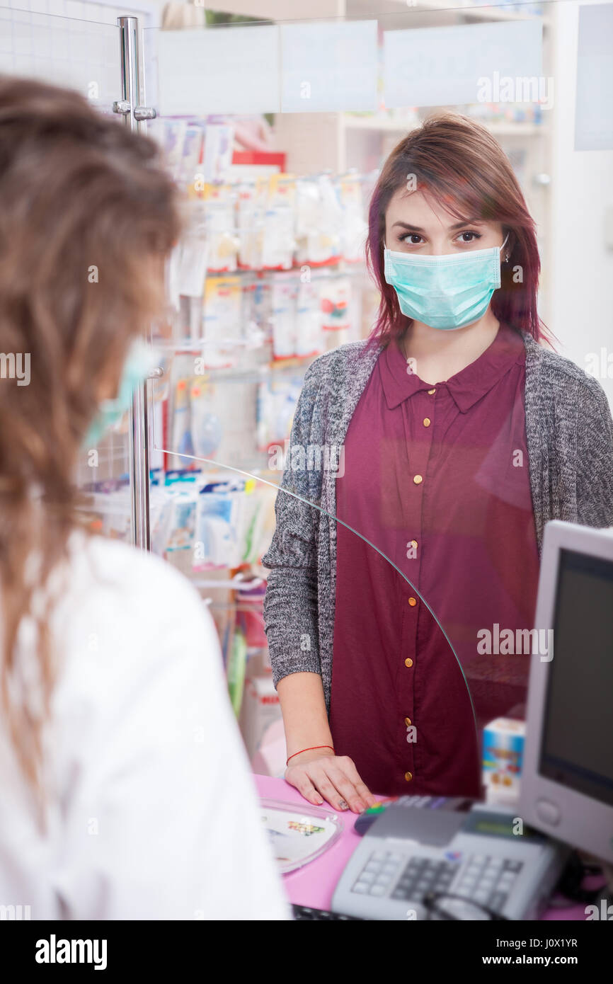 Pharmacist and her client in front of the desk Stock Photo - Alamy