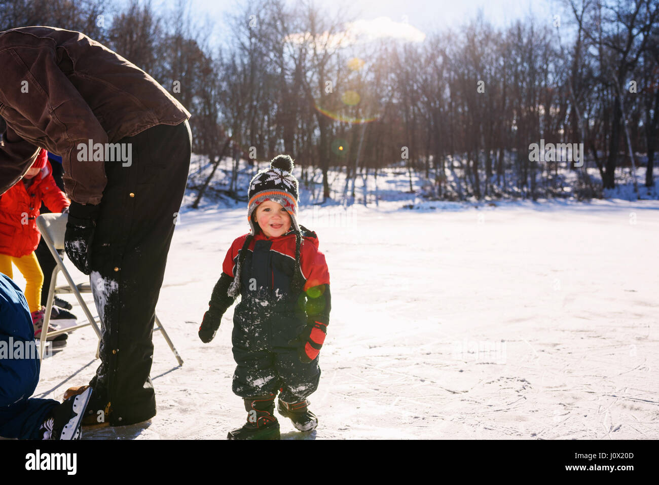 Father ice-skating with three children Stock Photo