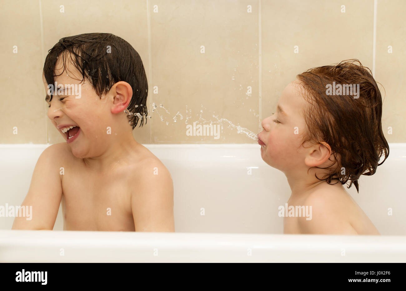 Two brother having a bath at home together. Stock Photo