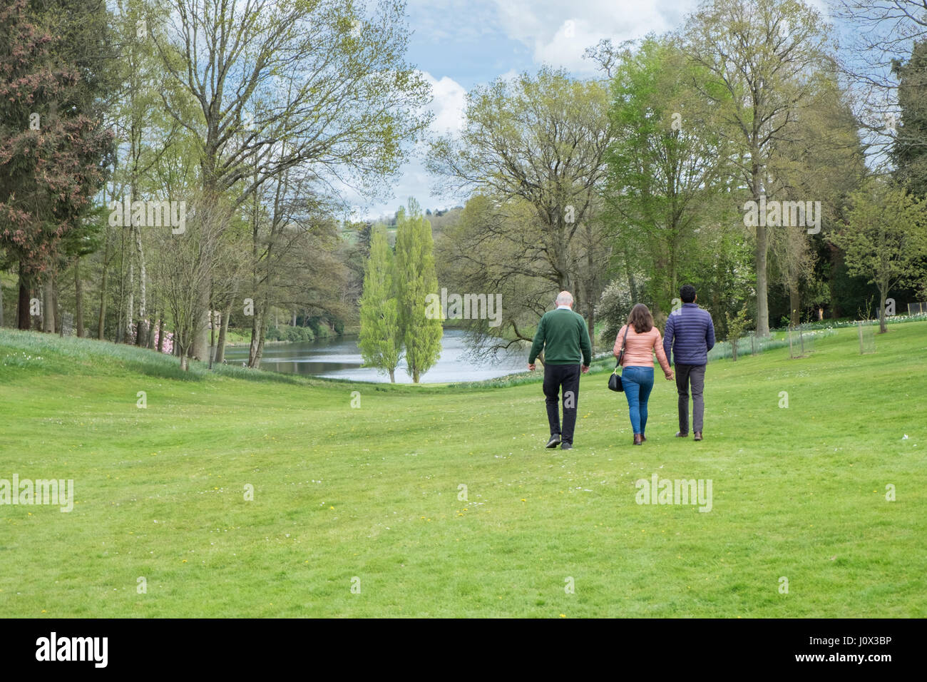 A tour guide escorting visitors around the gardens designed by capability brown at Bowood house near Calne in Wiltshire, UK Stock Photo